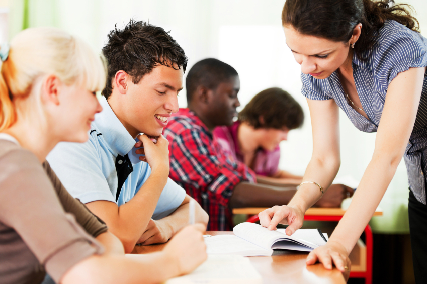 Teenage students in the classroom with teacher.